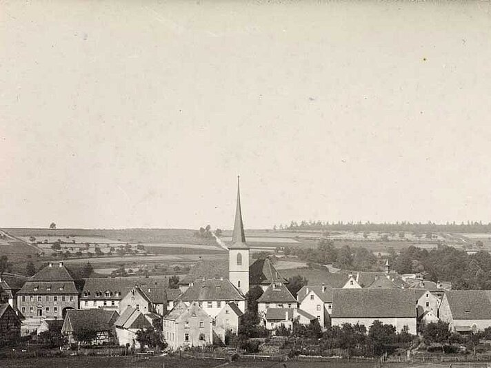 Blick auf das Dorf über Felder in schwarz-weiß / leicht sepia