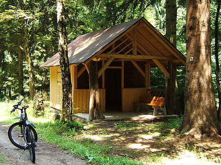 Hütte im Wald mit einem Fahrrad davor